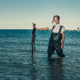 Chef Mathilde from restaurant Blink foraging seaweed by the beach in Skagen, North Jutland