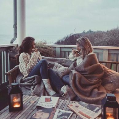 Two women having a cozy time on the terrace at Helenekilde Badehotel in Tisvilde during winter.