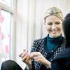 A business woman stands talking next to some post it notes in a business meeting in Denmark