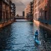 A man paddleboarding in a canal in Copenhagen, Denmark