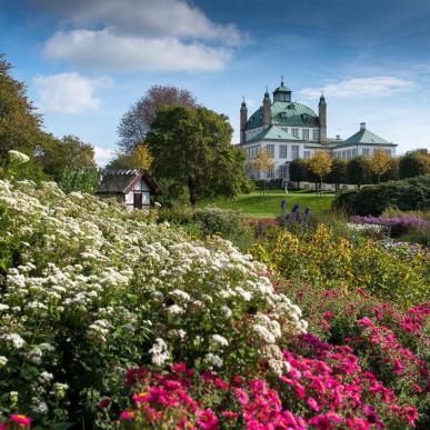 Fredensborg Schlossgarten mit Blumen im Vordergrund und dem Schloss im Hintergrund