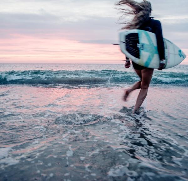 Surfer surfing at Klitmøller at sunrise, North Jutland