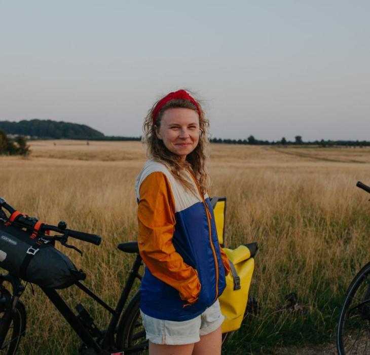 A lady stands with a bike in Hindsgavl National Park, Denmark