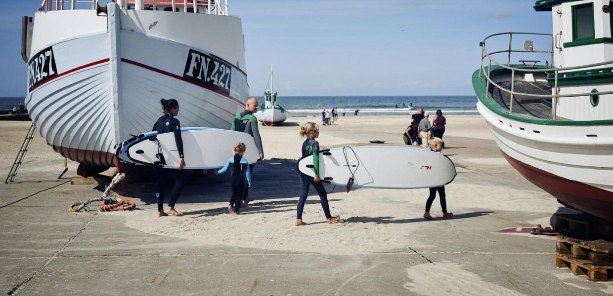 Family with surfboards on the beach at Løkken in North Jutland