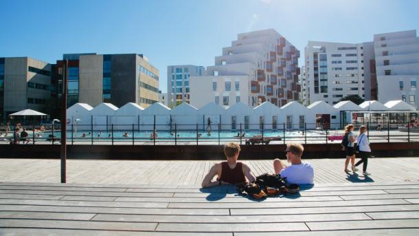 People enjoying the sun beside the harbour bath in Odense, Denmark