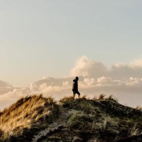 Boy walking on a windy sand dune in Klitmoeller, Thy National Park